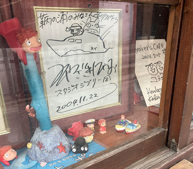 鞆の浦の店の軒先に飾られている宮崎駿監督のサインとポニョ.jpg